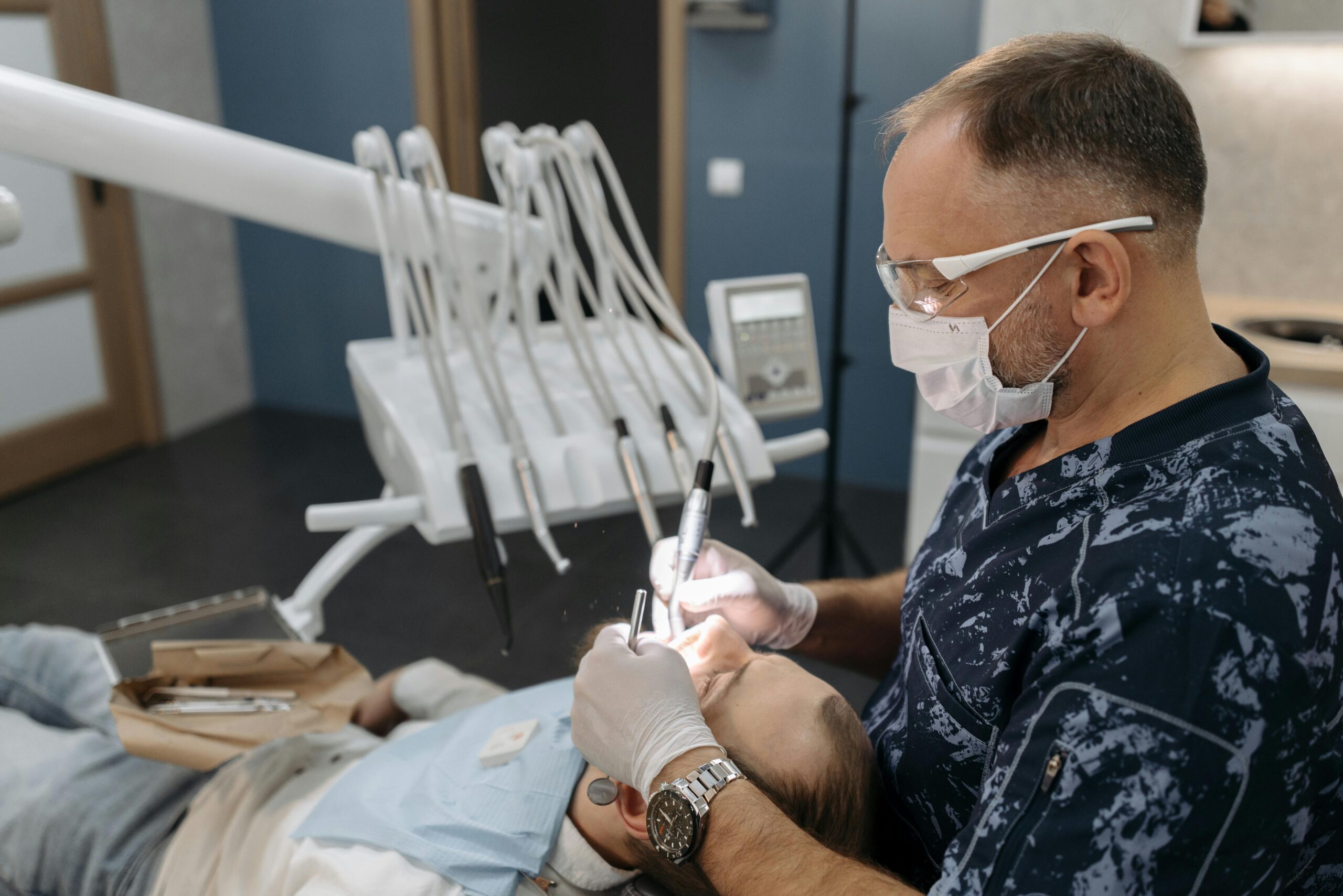 Dentist performing dental treatment on patient in modern dental clinic using professional tools